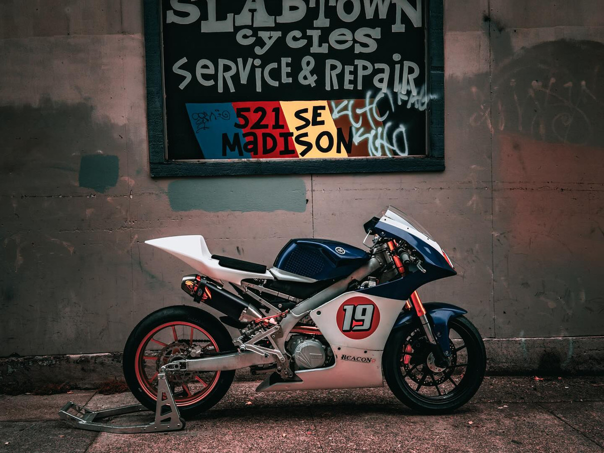 Yamaha race bike under the hand-painted Slabtown Cycles Service & Repair sign at 521 SE Madison, Portland