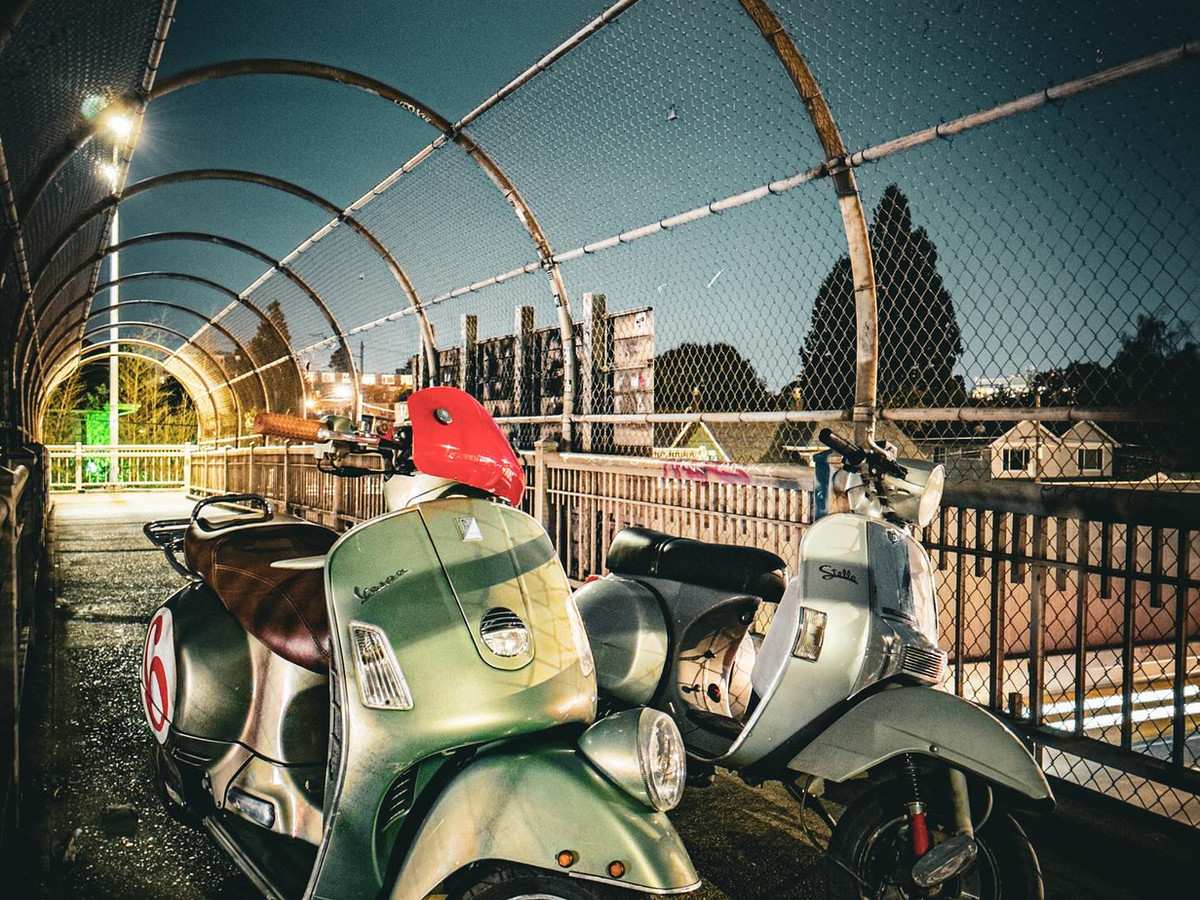 Two Vespas under an overpass at night